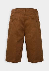 Shorts marron longueur genou avec passants de ceinture et deux poches arrière en passepoil boutonnées, vus de dos sur un fond uni.