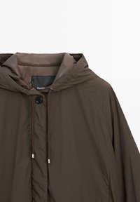 Braune Kapuzenjacke mit Knopfverschluss und Kordelzug, zeigt die obere Hälfte mit sichtbarem Kragen und Teil des rechten Ärmels.