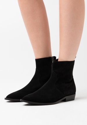 Zwarte nubuck enkellaarsjes met een puntige neus, elastische zijkanten en een kleine blokhak. Voorzien van een rits aan de achterkant voor gemakkelijk aan- en uittrekken.