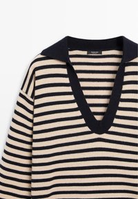 Maglione a righe con scollo a V, caratterizzato da strisce alternate blu navy e beige, e un colletto a contrasto blu navy. Realizzato in materiale morbido.