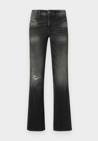 Čierne vyblednuté rozšírené džínsy s prednými vreckami, zapínaním na gombík a opotrebovanou záplatou na ľavom stehne.