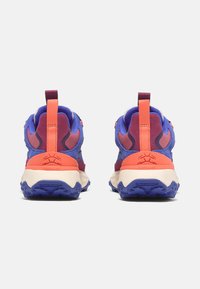 Rückansicht von bunten Turnschuhen mit einer Mischung aus blauen, lila und orangefarbenen Stoffen, einer strukturierten Sohle und einer kontrastierenden Fersenschlaufe.