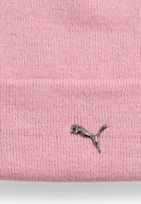 Berretto lavorato a maglia rosa chiaro con una consistenza morbida, caratterizzato da un logo Puma argentato vicino al bordo inferiore. Design semplice e classico con una vestibilità aderente.