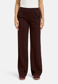 Burgundy wide-leg pants with a high waistband, featuring creases along the front and soft fabric texture, paired with burgundy shoes.