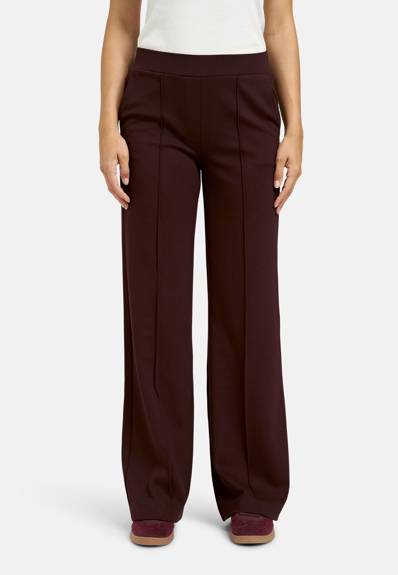 Burgundy wide-leg pants with a high waistband, featuring creases along the front and soft fabric texture, paired with burgundy shoes.