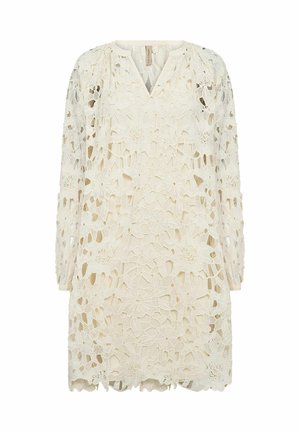 Vestido de encaje en marfil con recortes florales, escote en V, mangas largas y dobladillo con bordes en ondas. El patrón detallado añade textura y un interés en el diseño.