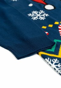 Knitted sweater with a navy blue base, featuring white snowflakes and colorful holiday patterns. Ribbed cuffs, soft texture.