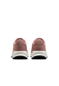 Zapatillas Nike con parte superior de malla rosa, suela blanca y suela de goma negra, que muestran un sutil detalle de marca en el talón.