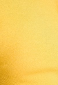 Tessuto giallo a coste con una superficie liscia, caratterizzato da un colore uniforme e da un motivo consistente su tutta la superficie.