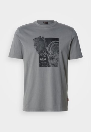 T-shirt gris à manches courtes avec col rond, orné d'un graphisme noir représentant deux cernes d'arbre et le mot « BOSS » imprimé en dessous.