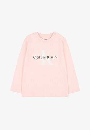 Maglietta per neonati a maniche lunghe rosa chiaro con logo Calvin Klein in lettere bianche e nere e due bottoni a pressione sulla spalla sinistra.