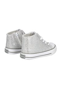 Zapatillas altas de purpurina plateada con suela de goma blanca, que cuentan con cordones y un zipper lateral para una fácil colocación. Superficie plana y texturizada.