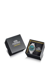 Reloj de metal plateado con un dial turquesa presentado en una caja de presentación negra y dorada con logotipo en relieve y superficie texturizada.