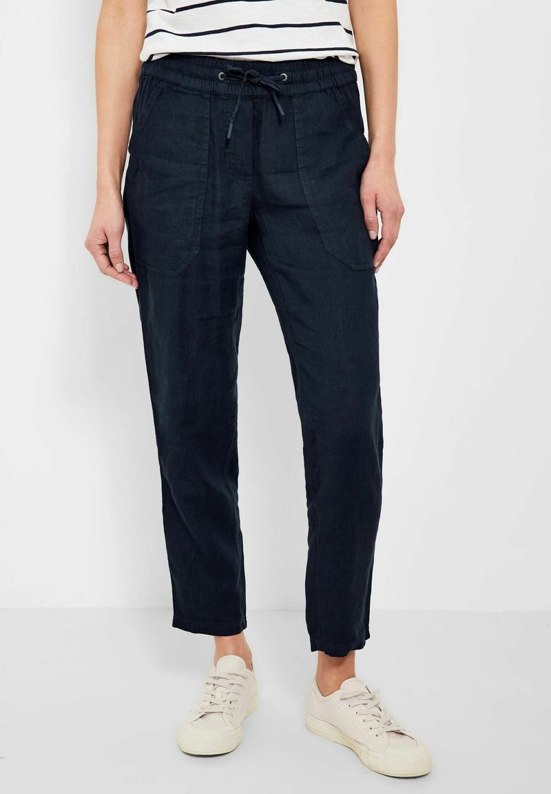 Granatowe spodnie z mieszanki lnu z elastycznym pasem, sznurkiem do regulacji i bocznymi kieszeniami. Posiadają zwężaną nogawkę i luźny krój.