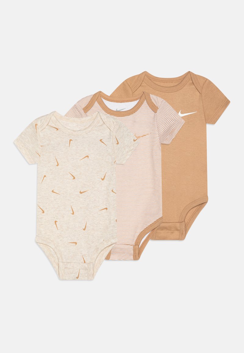 Trois bodies pour bébés en beige et tan. L'un a un motif de logo éparpillé, un autre a des rayures tan, et le dernier est un tan uni avec un logo.