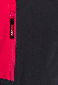 Schwarze und pinke Jacke mit einem seitlichen Reißverschluss und einem robusten Zugband, glatter Textur und einem kontrastierenden Farbstreifen für bessere Sichtbarkeit.