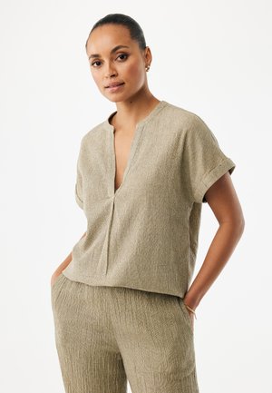 Krátký rukáv, světle béžový top s výstřihem do V, texturovaná látka a volný střih, doplněný o kalhoty se stejnou texturou.