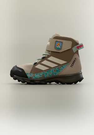 Παιδικό καφέ και μπεζ πεζοπορικό μποτάκι Adidas Terrex με πετρόλ σχέδια, λουράκι με βέλκρο και μαύρη ανθεκτική σόλα.