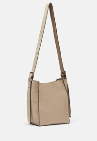 Borsa beige con una forma strutturata, caratterizzata da un esterno liscio, dettagli a contrasto neri sui bordi e una tracolla regolabile.