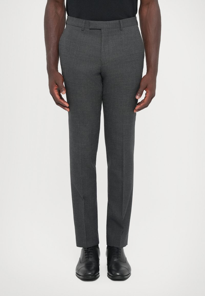 Pantalones grises a medida hechos de tela texturizada, con un corte slim, frente plano y bolsillos estándar, combinados con zapatos de vestir negros.
