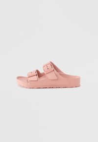 Rosa slidesandaler med to justerbare stropper, laget av teksturert gummimateriale, med en kraftig såle og et minimalistisk design.