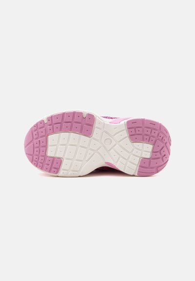 Semelle d'une chaussure de sport rose et blanche avec une semelle à motifs pour l'adhérence, positionnée à plat sur un fond blanc uni.