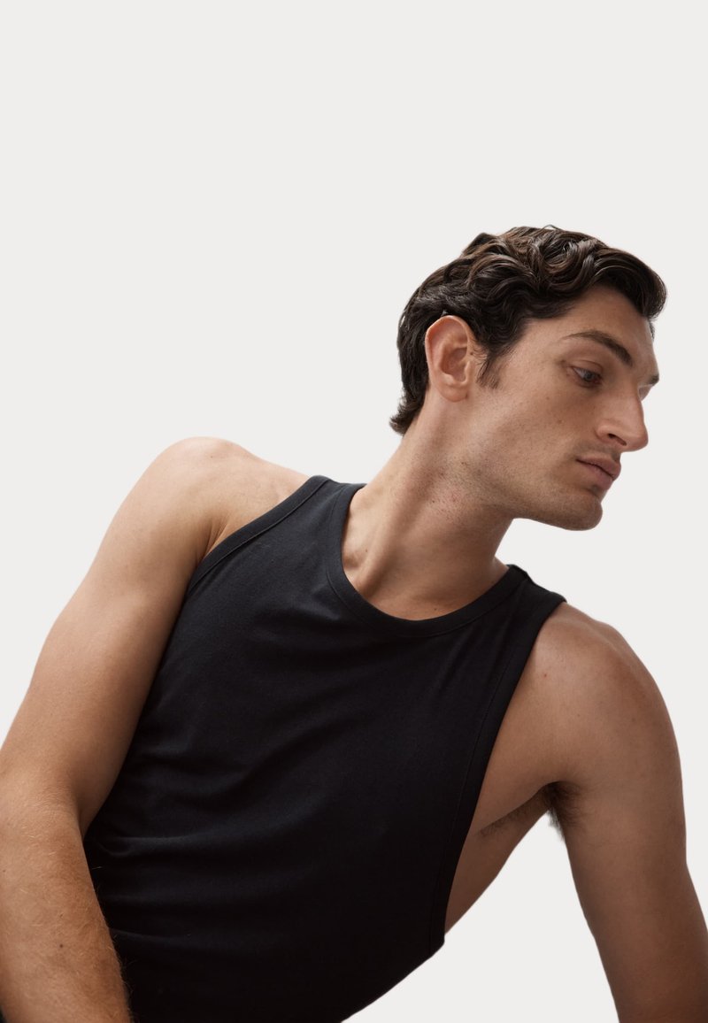 Zwarte mouwloze tanktop in een aansluitend design. Gemaakt van gladde stof, met een ronde halslijn en minimale naden.