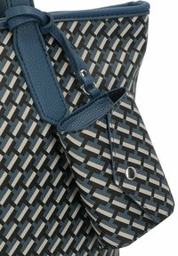 Grand sac fourre-tout avec un trim en cuir texturé bleu et un motif tissé en noir, blanc et bleu, avec une petite pochette attachée.