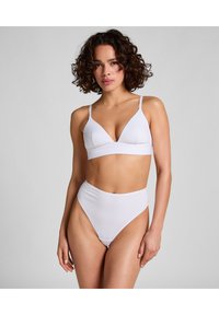 Sostén de algodón blanco con un diseño de copa triangular, tirantes ajustables y una parte inferior de bikini de tiro alto a juego con una textura suave.