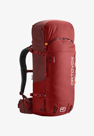 Red nylon backpack with a large top compartment, side zipper, adjustable straps, and padded back panel. Features mesh texture and external pockets.