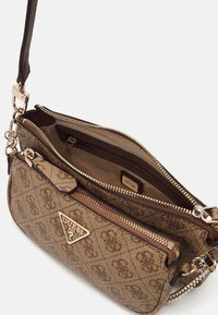 Borsa a tracolla marrone Guess con cerniere e logo dorati, esterno con motivo, scomparto principale aperto e tracolla removibile con dettaglio in catena dorata.