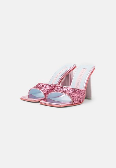Rožnate bleščeče sandale z odprtimi prsti in kvadratnim konico ter sijajnimi refleksivnimi detajli. Debeli prozorni bloki v petah zagotavljajo stabilnost.