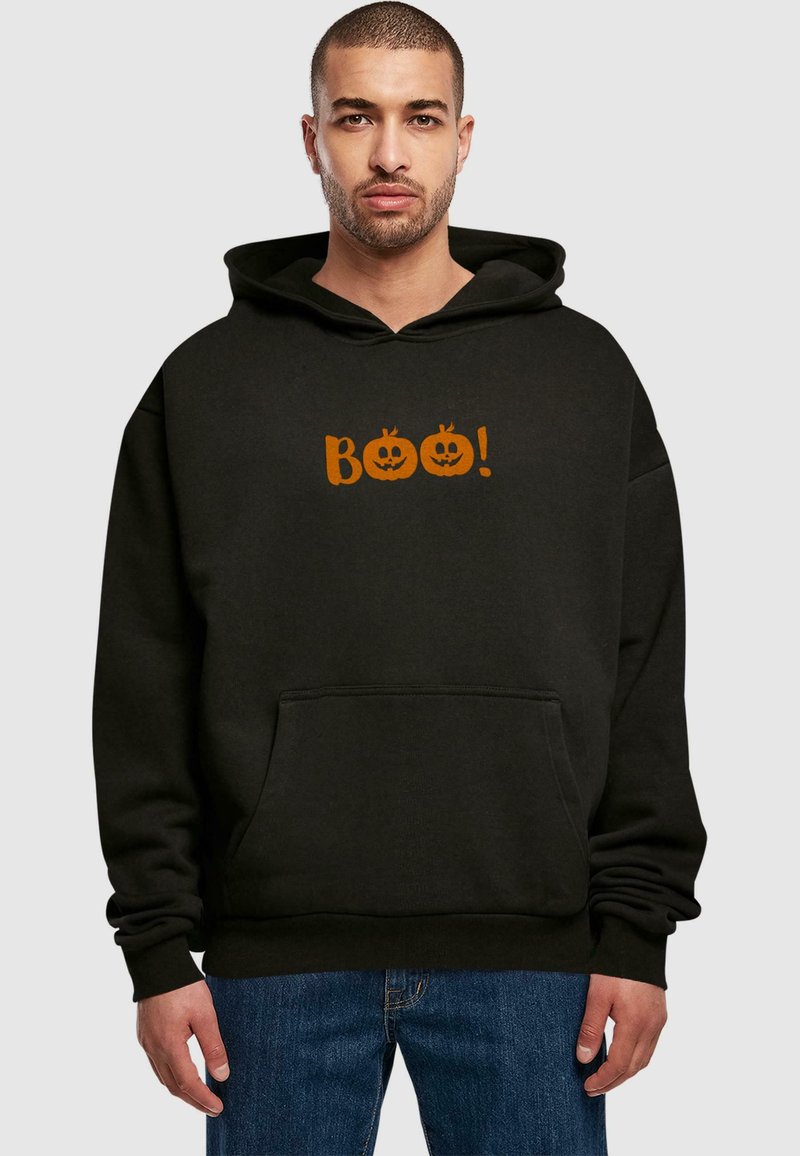 Čierna mikina s kapucňou a predným vreckom, s oranžovým textom "Boo!" nad dvoma ilustráciami tekvíc. Mäkká látka a voľný strih.