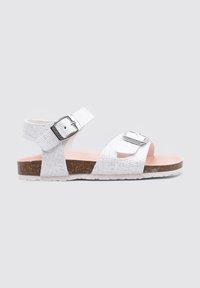 Sandalias blancas con parte superior de tela texturizada, correa ajustable con hebilla plateada, plantilla de corcho y suela de caucho blanca.