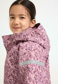 Paarse bloempatronen jas met een capuchon, voorzien van een zilveren accent op de schouder. Het materiaal lijkt glad en lichtgewicht te zijn.