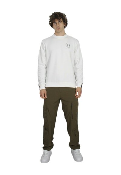 Felpa bianca con collo a barco e piccolo logo nero sul lato sinistro del petto, abbinata a pantaloni cargo verde oliva con tasche laterali e cerniere.