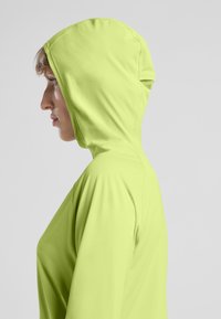 Limegrüner Kapuzenpullover aus weichem, leichtem Material mit einem schlanken Design, ausgestattet mit einer enganliegenden Kapuze und langen Ärmeln.
