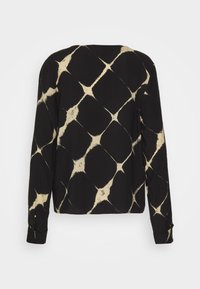 Maglietta nera a maniche lunghe con un motivo a rombi color crema, realizzata in un tessuto morbido, con vestibilità rilassata e polsini abbottonati.