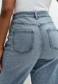 Džíny z modrého denimu s vysokým pasem a strukturovaným povrchem, s dvěma zadními kapsami a jemnými detaily prošití.