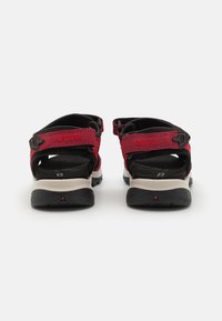 Raudoni ir juodi Ecco sandalai su reguliuojamomis dirželis, patvaria medžiaga, paminkštintomis įdėklomis ir tvirtu guminio pado su tekstūruota paviršiumi.