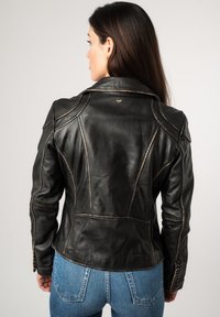 Zwarte leren jas met gestructureerde naden, zichtbare stikseldetails en een notch-kraag. Gladde textuur, getailleerd ontwerp en een logoborduring aan de achterkant.