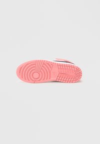 Talpă de pantof Nike din cauciuc roz, cu un model texturat al tălpii. Talpă intermediară albă netedă cu accente negre și detalii de marcă.