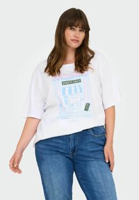 Balta per didelė T-marškiniai su spalvinga kavinės grafika. Derinama su mėlynomis džinsinėmis kelnėmis. Pagaminta iš medvilnės, laisvas kirpimas, trumpomis rankovėmis.