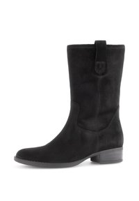 Bota de ante negra hasta la rodilla con una textura suave, puntera redonda y costuras mínimas. Presenta una sutil pestaña de tiro en la parte superior y un tacón bajo.