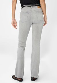 Grijze flared jeans met een reguliere pasvorm, vijf zakken en een gladde textuur. De tailleband is voorzien van een zwarte riem en een gelabelde leren patch.