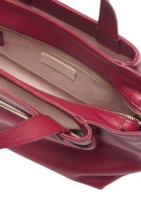 Borsa a mano rossa in pelle con una superficie testurizzata, doppio manico e un compartimento con zip. L'interno è beige con un'etichetta del marchio visibile.