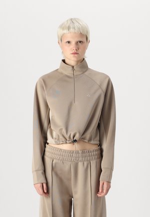Beige kort sweatshirt med høy krage og halvmollet, med teksturert stoff og justerbar snøring i livet. Løs passform på ermene.