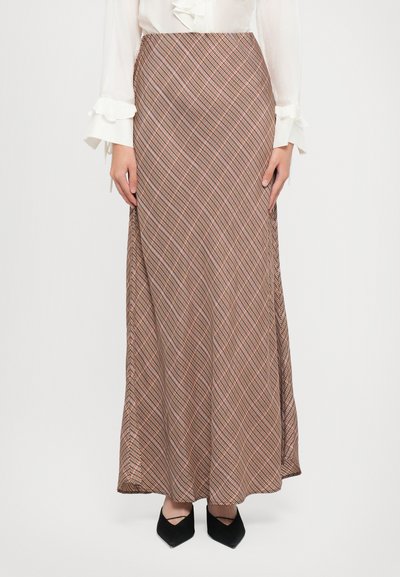 Jupe longue en tartan marron avec une silhouette fluide. Présente un motif diagonal avec des accents subtils rouges et blancs, fabriquée en tissu léger.