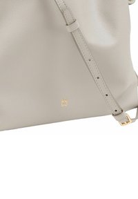 Borsa a tracolla in pelle grigia, con logo dorato in rilievo e superficie liscia. Tracolla regolabile con più fori.