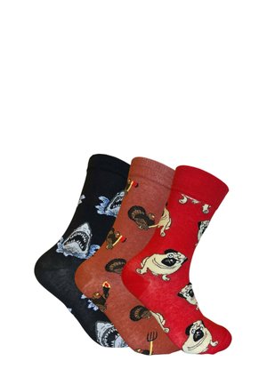 Three pairs of cotton socks: black with shark graphic, rust with turkey motif, and red featuring pugs. Each has ribbed cuffs and unique designs.